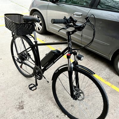 Bicicleta eléctrica Frank completa, vista lateral, con canasto y guardabarros